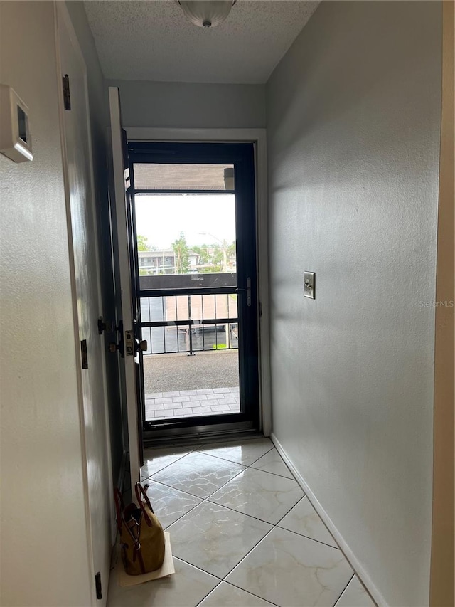 entryway featuring baseboards and a textured ceiling