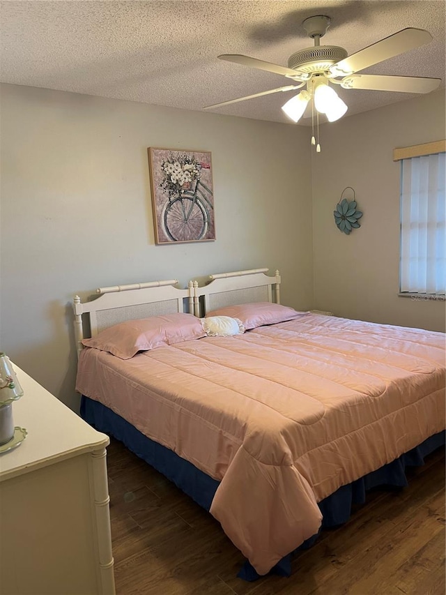 bedroom with ceiling fan, a textured ceiling, and wood finished floors