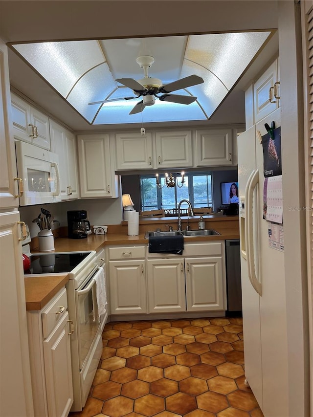 kitchen featuring white appliances, ceiling fan, white cabinetry, and light countertops