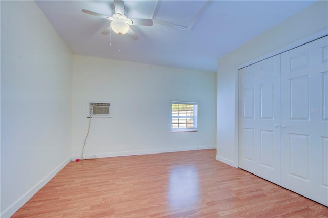 unfurnished bedroom with light hardwood / wood-style floors, a wall mounted AC, ceiling fan, and a closet