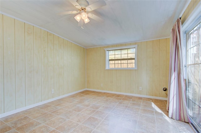 empty room featuring wooden walls and ceiling fan