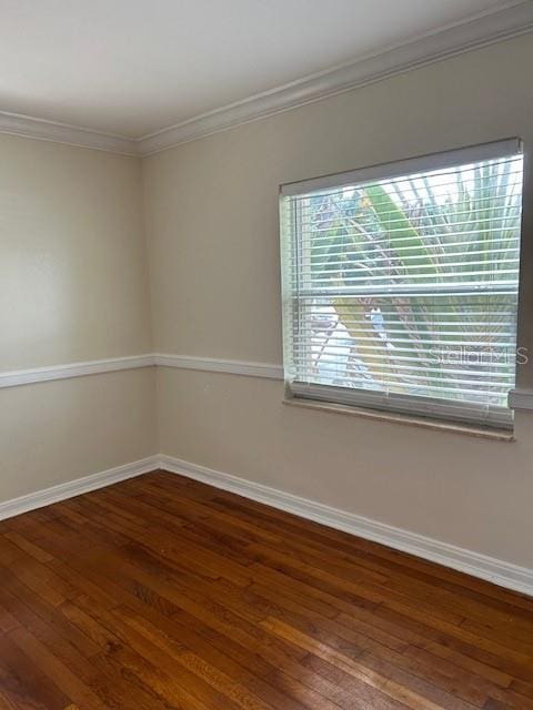 unfurnished room with dark wood-type flooring and crown molding