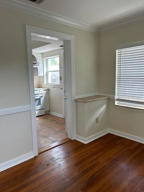 interior space featuring white range, hardwood / wood-style floors, and crown molding