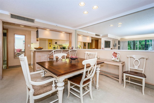 carpeted dining area featuring ornamental molding