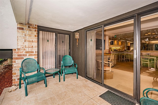 interior space with light tile floors, a textured ceiling, and brick wall