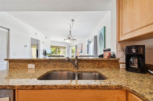 kitchen featuring sink and light stone counters