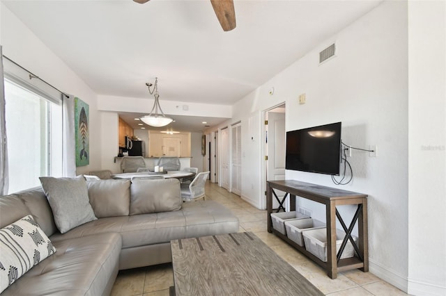 tiled living room with ceiling fan