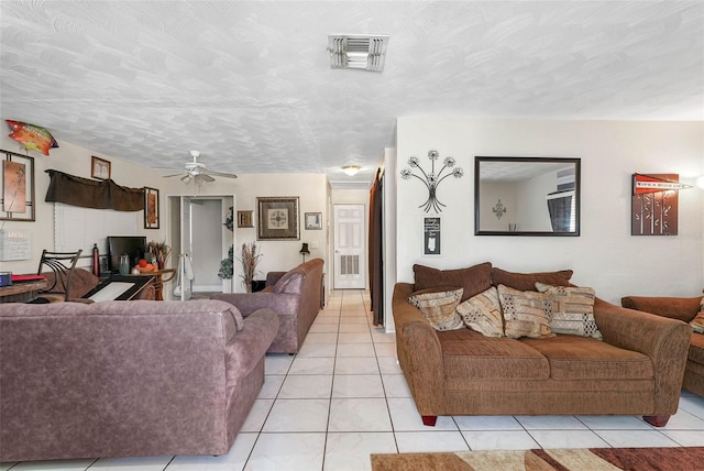 tiled living room with ceiling fan and a textured ceiling