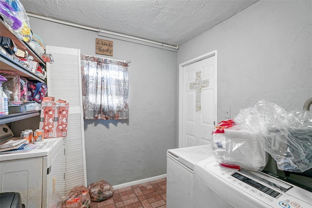 clothes washing area featuring a textured ceiling, tile floors, and washing machine and dryer