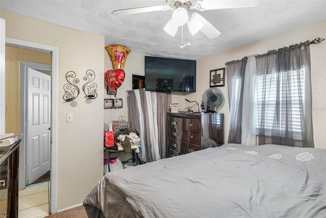 tiled bedroom featuring ceiling fan