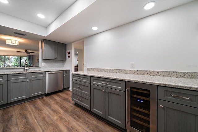 kitchen featuring dark hardwood / wood-style floors, ceiling fan, gray cabinetry, stainless steel dishwasher, and beverage cooler