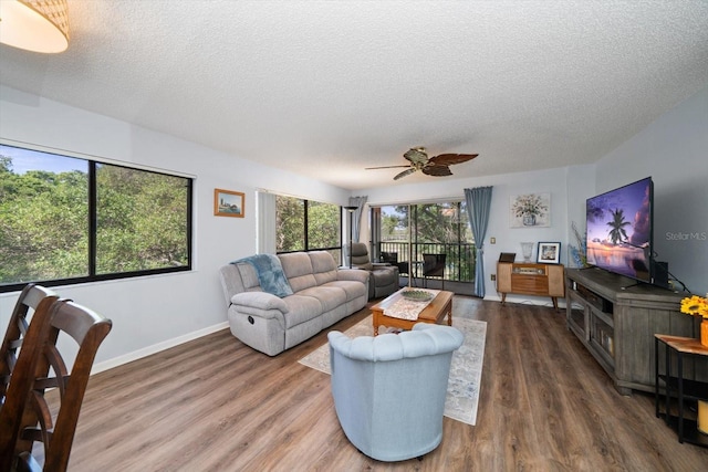 living room with dark hardwood / wood-style flooring, a textured ceiling, and ceiling fan