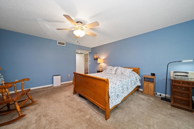 carpeted bedroom featuring ceiling fan and a textured ceiling