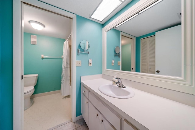 bathroom with toilet, oversized vanity, and tile flooring