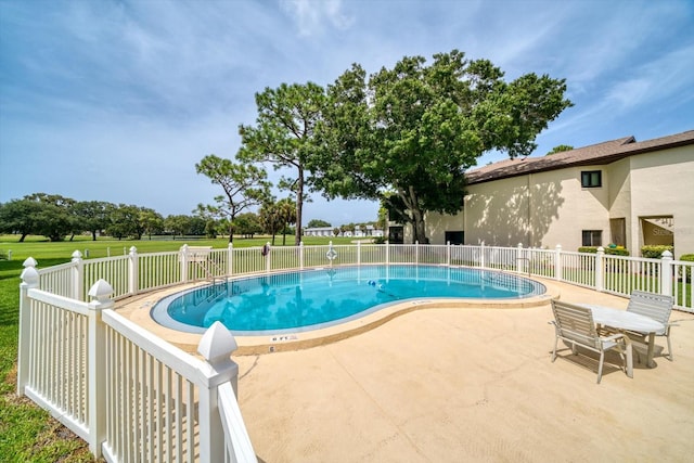 view of pool with a lawn and a patio