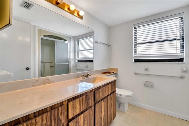 bathroom featuring vanity, a shower with shower door, and toilet