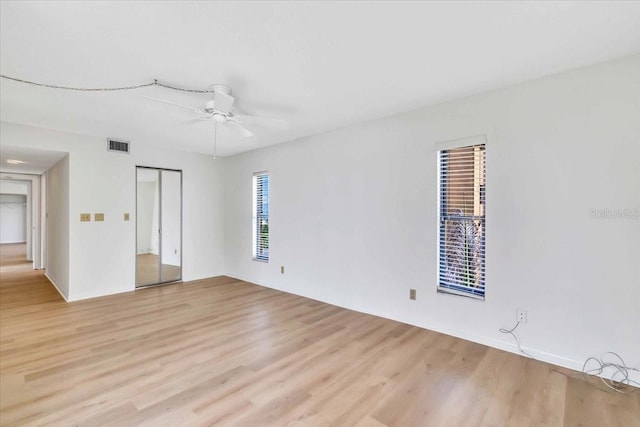 empty room with ceiling fan and light wood-type flooring