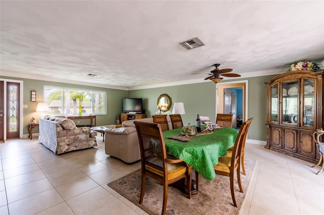 tiled dining space featuring crown molding and ceiling fan