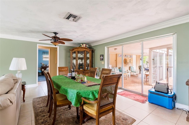 tiled dining room featuring crown molding and ceiling fan