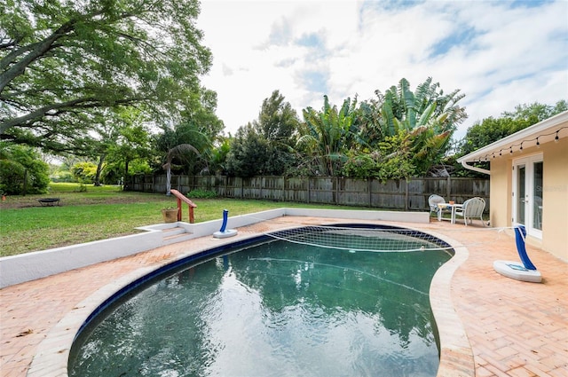 view of pool featuring a lawn and a patio