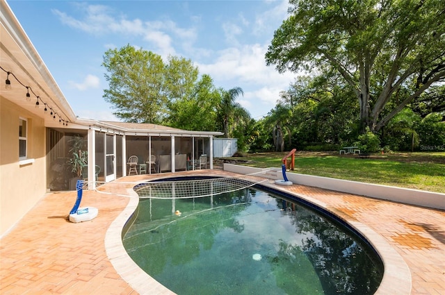 view of pool with a lawn and a patio