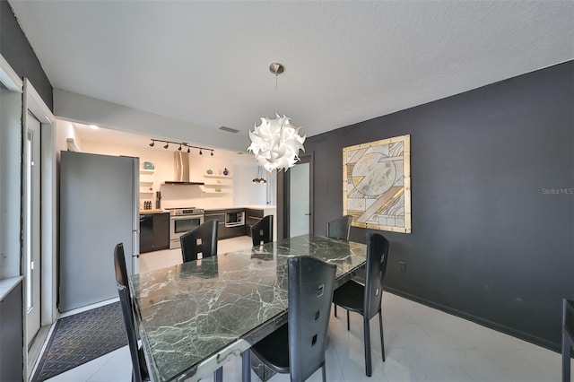 dining area with a textured ceiling and a notable chandelier