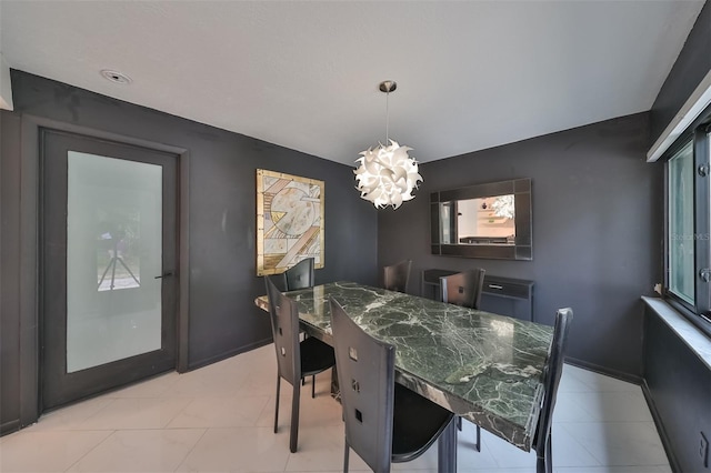 dining area with light tile patterned floors and an inviting chandelier