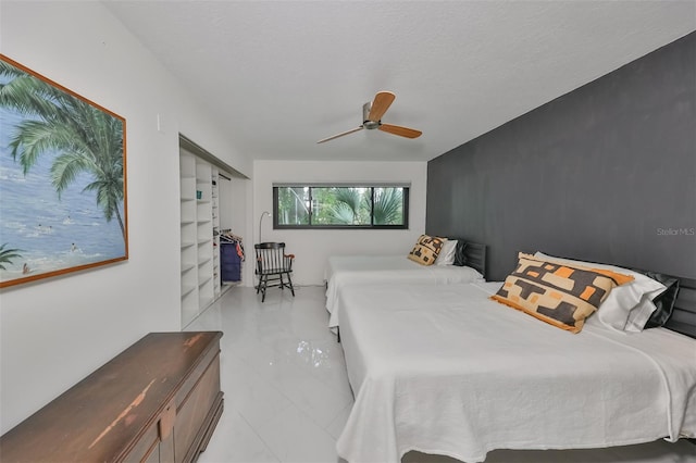 bedroom with ceiling fan, a closet, and a textured ceiling