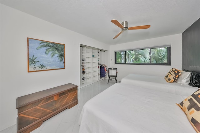 bedroom featuring ceiling fan and a textured ceiling