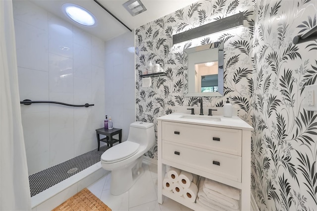 bathroom featuring tile patterned floors, vanity, a tile shower, and toilet