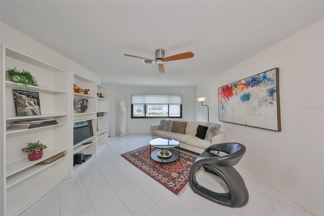 living room featuring ceiling fan and a textured ceiling