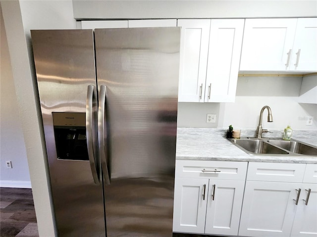 kitchen featuring white cabinetry, sink, stainless steel fridge, and dark hardwood / wood-style floors