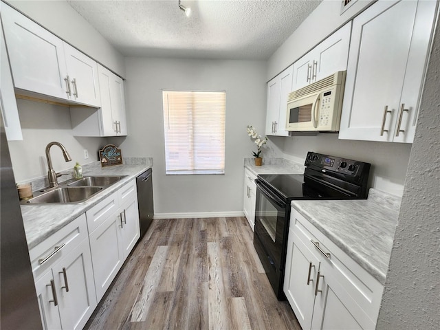 kitchen featuring white cabinets, sink, hardwood / wood-style floors, and black appliances