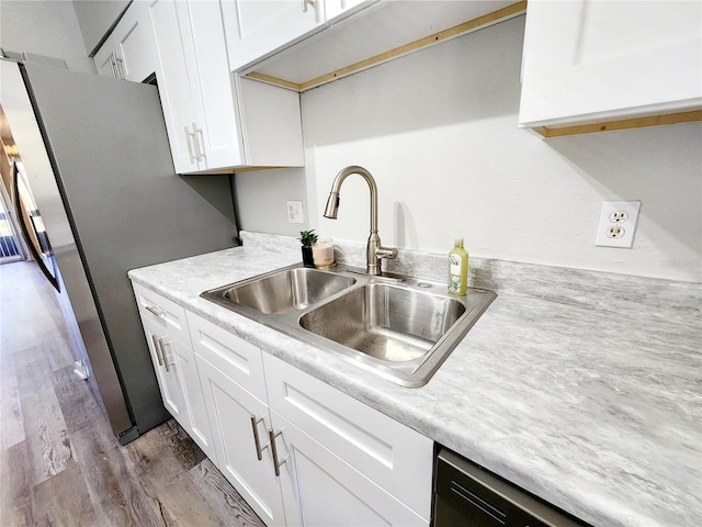 kitchen featuring light wood-type flooring, sink, and white cabinets