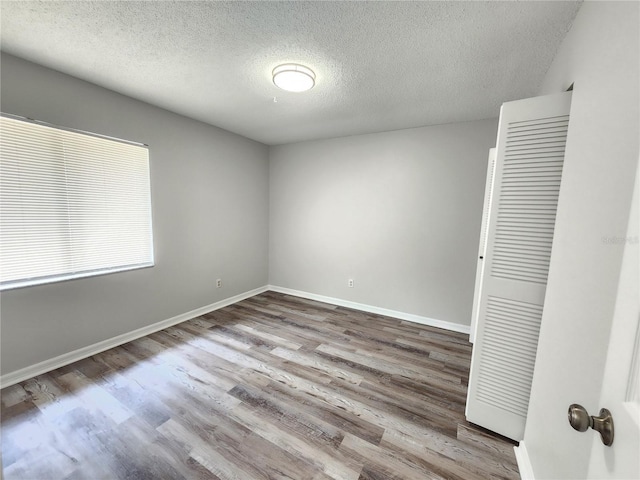 unfurnished bedroom with hardwood / wood-style floors and a textured ceiling