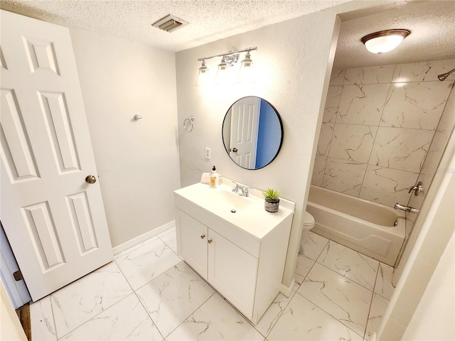 full bathroom featuring vanity, tiled shower / bath, toilet, and a textured ceiling