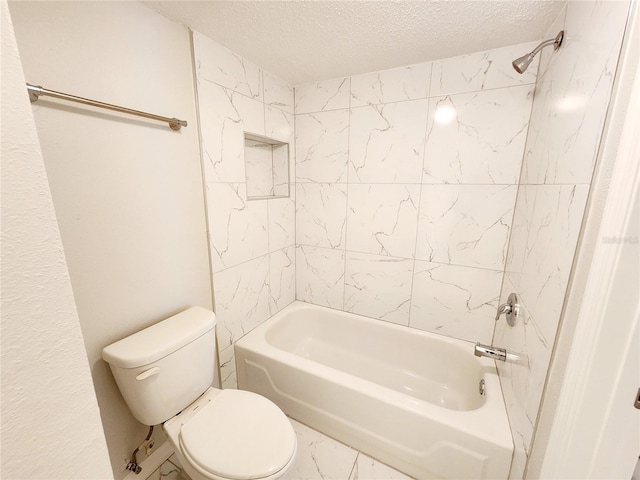 bathroom with tiled shower / bath, a textured ceiling, and toilet