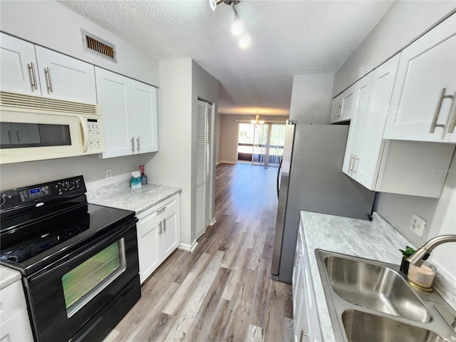 kitchen with black range with electric stovetop, sink, a textured ceiling, and white cabinets