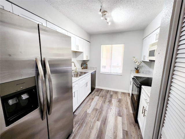 kitchen featuring stainless steel appliances, sink, and white cabinets