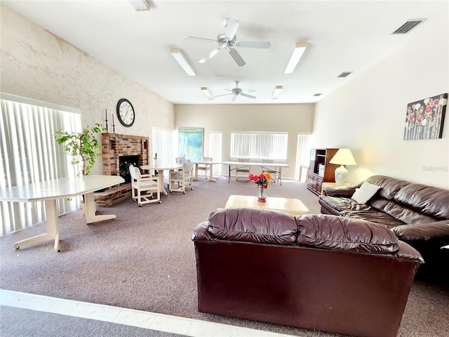 carpeted living room with a fireplace and ceiling fan