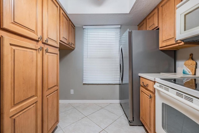 kitchen with white appliances and light tile floors