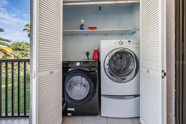 laundry room with washing machine and clothes dryer, hookup for an electric dryer, and light tile floors