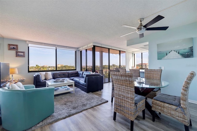 living room featuring hardwood / wood-style floors, floor to ceiling windows, a textured ceiling, and ceiling fan