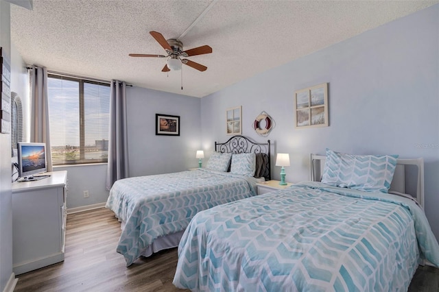 bedroom featuring hardwood / wood-style floors, a textured ceiling, and ceiling fan