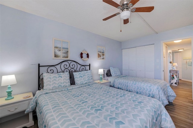 bedroom with hardwood / wood-style flooring, ceiling fan, a closet, and a textured ceiling