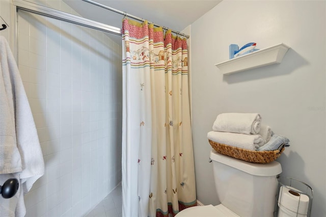 bathroom featuring a shower with curtain and toilet
