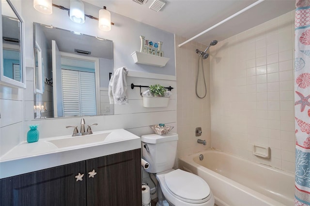 bathroom with visible vents, shower / tub combo with curtain, toilet, tile walls, and vanity