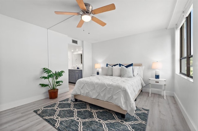 bedroom with ceiling fan, light hardwood / wood-style flooring, and ensuite bathroom