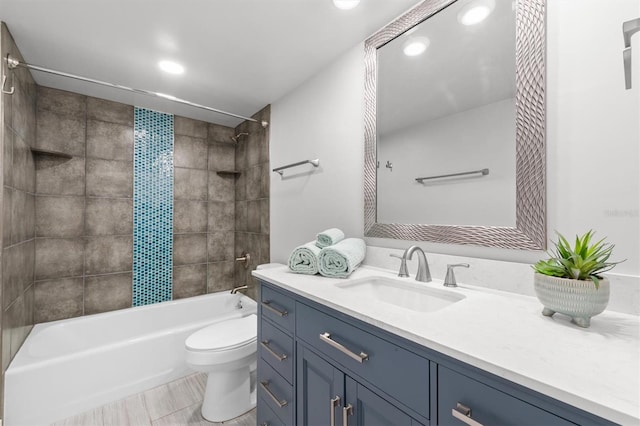 full bathroom with toilet, large vanity, tiled shower / bath, and tile flooring