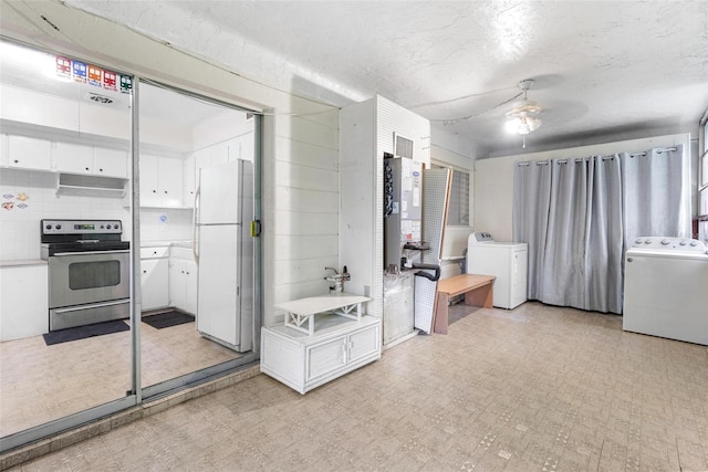 kitchen featuring white fridge, ceiling fan, white cabinetry, and stove